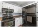 Kitchen showcasing white cabinetry, black appliances, and ample counter space for cooking at 828 Williamsburg Ln, Charleston, SC 29414