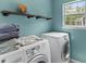 Convenient laundry room with washer, dryer, shelving, and a sunlit window at 828 Williamsburg Ln, Charleston, SC 29414