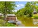 Picturesque pond featuring a wooden dock, surrounded by lush trees, adding natural beauty to the property at 828 Williamsburg Ln, Charleston, SC 29414