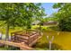 Pond view showcasing a wooden dock surrounded by mature trees, providing a peaceful waterfront setting at 828 Williamsburg Ln, Charleston, SC 29414