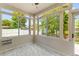 Bright sun room with large windows offering serene views of the outdoor landscape and stylish tile flooring at 828 Williamsburg Ln, Charleston, SC 29414