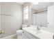 Clean bathroom with white vanity, toilet, mirror, and shower with a neutral colored wall at 8676 Grassy Oak Trl, North Charleston, SC 29420