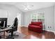 Bright bedroom features hardwood floors, a ceiling fan, and a comfortable red couch at 8676 Grassy Oak Trl, North Charleston, SC 29420