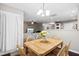 Open dining room with hardwood floors, a wooden table, and view into the living room at 8676 Grassy Oak Trl, North Charleston, SC 29420