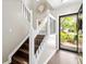 Welcoming entryway with hardwood floors, decorative staircase, and natural light from front door at 8676 Grassy Oak Trl, North Charleston, SC 29420
