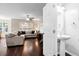 A view of a spacious living room with hardwood floors, a sectional sofa, and an adjacent half bathroom at 8676 Grassy Oak Trl, North Charleston, SC 29420