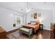 Bright main bedroom featuring large window, hardwood floors, and vaulted ceiling at 8676 Grassy Oak Trl, North Charleston, SC 29420