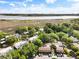 An aerial view of residential buildings in a lush, green community with a marsh and distant city view at 870 Colony Dr # 14, Charleston, SC 29407