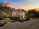 A charming two-story brick home with parking in front during a vibrant sunset at 870 Colony Dr # 14, Charleston, SC 29407