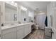 Bright bathroom featuring double sinks, quartz countertops, and a shower with a striped curtain at 928 Sycamore Ave, Charleston, SC 29407