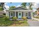Charming gray home featuring a welcoming porch, aqua front door, and well-maintained landscaping at 928 Sycamore Ave, Charleston, SC 29407