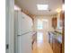 A practical kitchen featuring light-colored wood cabinets, appliances and a view into the dining area at 9630 N Cardinal Dr, Ladson, SC 29456