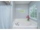 Clean bathtub with a shower curtain and a small window, providing a relaxing space at 9636 Pebble Creek Blvd, Summerville, SC 29485