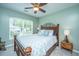 Cozy bedroom with a ceiling fan, beautiful wood bed frame, and large window for lots of natural light at 9636 Pebble Creek Blvd, Summerville, SC 29485