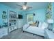 Well-lit bedroom with light blue walls, a ceiling fan, a bookcase, dresser, and comfortable looking bed at 9636 Pebble Creek Blvd, Summerville, SC 29485
