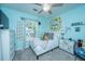 Bright bedroom with light blue walls, ceiling fan, decorative wall art, and a view through the window at 9636 Pebble Creek Blvd, Summerville, SC 29485
