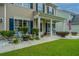 Inviting front porch with decorative plants and an American flag, adding charm and curb appeal at 9636 Pebble Creek Blvd, Summerville, SC 29485