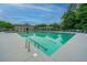 A community pool with chairs, tables, a bath house, and trees in the background offers a great recreational space at 9636 Pebble Creek Blvd, Summerville, SC 29485