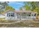 Charming home with a red metal roof, white siding, and a cozy front porch with flower baskets at 9666 Jamison Rd, Ladson, SC 29456