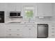Bright kitchen with white cabinets, granite countertops, and stainless steel appliances at 9666 Jamison Rd, Ladson, SC 29456