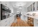 Bright kitchen features white cabinets, stainless appliances, and wood floors at 9666 Jamison Rd, Ladson, SC 29456