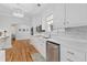 Bright kitchen features wood floors, white cabinets, stainless appliances, and a stylish backsplash at 9666 Jamison Rd, Ladson, SC 29456