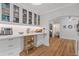 Charming kitchen features white cabinets with glass doors and wood floors at 9666 Jamison Rd, Ladson, SC 29456