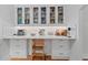 Bright kitchen features white cabinets with glass doors and wood floors at 9666 Jamison Rd, Ladson, SC 29456