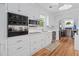 Bright kitchen features white cabinets, stainless appliances, and wood floors at 9666 Jamison Rd, Ladson, SC 29456