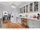 Charming kitchen features white cabinets with glass doors and wood floors at 9666 Jamison Rd, Ladson, SC 29456