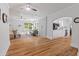 Bright, open living room with hardwood floors, modern furnishings, and white brick accent wall flowing into a kitchen at 9666 Jamison Rd, Ladson, SC 29456