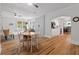 Open concept living space with hardwood floors, a brick accent wall, and a view to the kitchen at 9666 Jamison Rd, Ladson, SC 29456