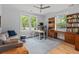 Sun-filled home office with hardwood floors, large windows, and functional desk setup with lots of storage at 9666 Jamison Rd, Ladson, SC 29456