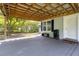 Covered porch with wood decking, window with blue shutters, bench, and charcoal grill at 9666 Jamison Rd, Ladson, SC 29456