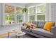 Cozy sunroom with lots of natural light and a comfortable gray sofa with yellow pillows at 9666 Jamison Rd, Ladson, SC 29456