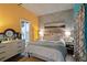 Cozy bedroom with yellow walls, concrete accent wall, and a queen size bed at 1 Cool Blow St # 344, Charleston, SC 29403