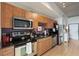 Modern kitchen with stainless steel appliances, wooden cabinets, and granite countertops at 1 Cool Blow St # 344, Charleston, SC 29403