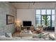 Bright living room featuring a comfortable sofa, large windows, and a leafy green plant at 1 Cool Blow St # 344, Charleston, SC 29403