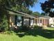 Traditional brick home with green shutters, a well-manicured lawn and mature trees at 1010 Foxcroft Rd, Charleston, SC 29412