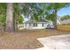 Backyard with patchy grass with a white house with a black roof, and a light colored truck at 1014 Alamo St, North Charleston, SC 29405