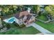 An aerial view of a two-story brick home featuring a private pool in a lush, green neighborhood at 102 Six Point Ct, Goose Creek, SC 29445