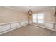 A well-lit dining room features wainscoting, an ornate chandelier, and plush carpet at 102 Six Point Ct, Goose Creek, SC 29445