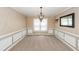 Formal dining room with elegant chandelier, wainscoting, and neutral paint at 102 Six Point Ct, Goose Creek, SC 29445