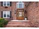 Gorgeous front door, showcasing the brick steps and facade, stylish lanterns, and manicured plants at 102 Six Point Ct, Goose Creek, SC 29445