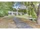 Scenic backyard featuring a serene pond with a pathway leading to the home, surrounded by lush greenery at 108 Greenmeadow Dr, Goose Creek, SC 29445