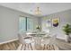 Modern dining area featuring a glass-top table, white chairs, a chandelier, and a large window at 108 Greenmeadow Dr, Goose Creek, SC 29445