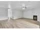 Spacious living room with light wood floors, ceiling fan, and a cozy fireplace, perfect for relaxation and entertainment at 108 Greenmeadow Dr, Goose Creek, SC 29445