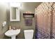 Compact bathroom featuring a pedestal sink, toilet, and shower with a patterned curtain at 109 Williams Ct, Goose Creek, SC 29445