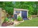 Landscaped backyard featuring a shed, mulched beds, lush greenery, and solar lights at 113 Ashton Cv, Summerville, SC 29485