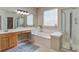 A well-lit bathroom with a separate shower and tub, vanity area, and decorative glass block window at 113 Ashton Cv, Summerville, SC 29485